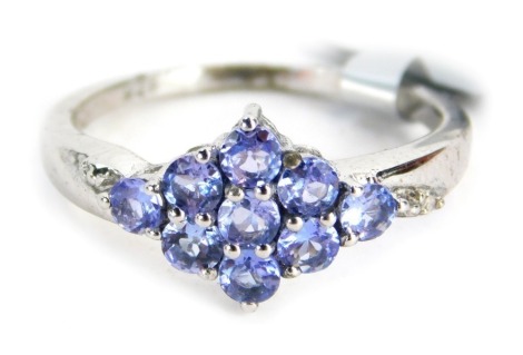 A tanzanite and diamond dress ring, central cluster design with tanzanite marker and tiny diamond set shoulders, white metal, marked 925, ring size O, 2.2g all in.