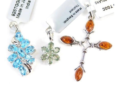 Three Gemporia pendants, comprising a crucifix with amber ends, green stone floral pendant, and a blue stone floral pendant, each in white metal stamped 925, with tags and pouches.