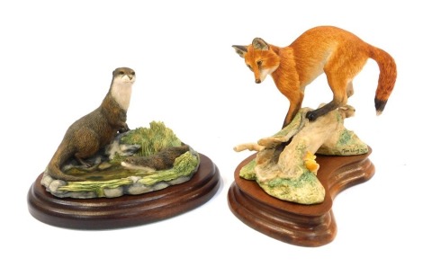 Two Border Fine Arts figure groups, comprising fox and hare on bough, on hardwood stand, 13cm high, and otter and cub, SWW1, on hardwood stand. (2)