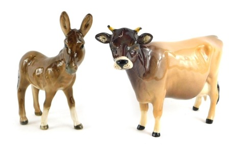 A Beswick pottery figure modelled as a cow, 10cm high, and a donkey foal, 11cm high. (2)