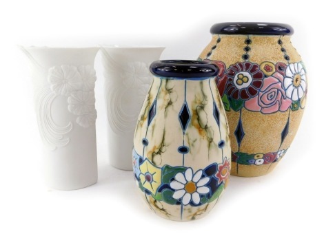 A Czechoslovakian Amphcra relief moulded vase, of cylindrical tapering form, decorated with flowers, 24cm high, another together with two Kaiser matt porcelain vase, of cylindrical compressed form, flared neck, decorated in relief with flowers, 19cm high