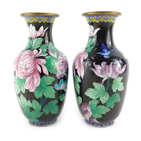 A pair of Japanese cloisonne vases, each of cylindrical tapering form, with flared neck, decorated with chrysanthemums and birds, against a black ground, 21cm high.