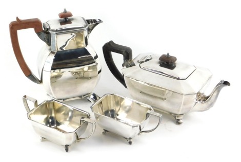 An Art Deco electroplated four piece tea set, comprising teapot, hot water jug, two handled sugar bowl and milk jug, each with tapering form, with inverted edges, hot water jug, 22cm high.