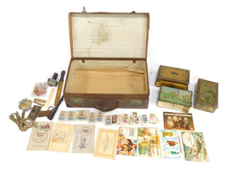 A 20thC leather case, containing various bygones, collectables, etc, to include Players Navy Cut cigarette cards, bygone tins, miniature pencils, whistles, wooden page turner, dated 1899, AA Road badge, etc., the case 56cm wide.