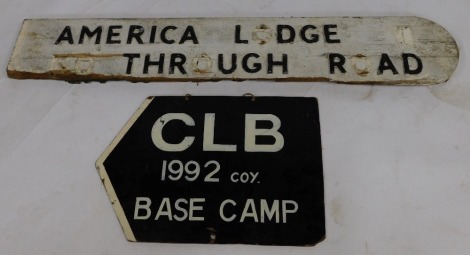 A painted wooden road sign, bearing painted metal letters for America Lodge Through Road, some letters lacking, 122cm wide, together with a cardboard sign for CLB 1992 Coy Base Camp, 56cm wide. (2)