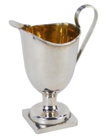 A late Victorian silver cream jug, of helmet form, on a square base, Birmingham 1896, 2.24oz, 11cm high.