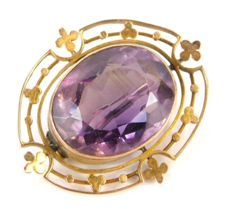 A late Victorian/Edwardian oval brooch, with central oval faceted amethyst in rub over setting, with relief clover outer border, yellow metal frame stamped 9ct, 3cm wide, 5.5g all in.