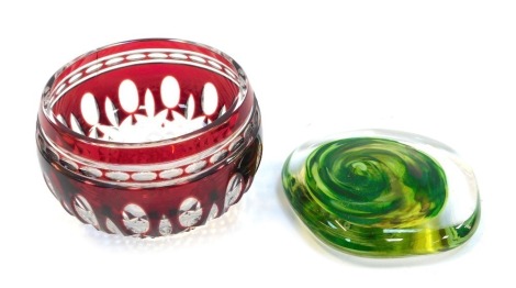 A Bohemian cranberry flash glass bowl, 9cm diameter, together with a glass paperweight, of compressed form, decorated internally with a central multi tonal green swirl, signed to base Shaws Reunion 2018, 9cm wide.