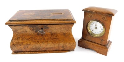 An early 20thC oak and inlaid mantel clock, the circular enamel dial bearing Arabic numerals, 14cm high, together with a Georgian burr wood tea caddy converted as a money box, with two holes to the top for coins, with key, 20cm wide.