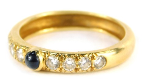 A sapphire and diamond wedding band, the raised sapphire in rub over setting flanked by four round brilliant cut diamonds, approx 0.04cts, to each side, on a yellow metal band, unmarked, size M 1/2, 2.5g all in.