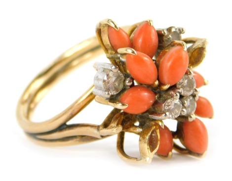 A Kutchinsky coral and diamond set dress ring, the oval coral in claw setting set with five round brilliant cut diamonds, each approx 0.01cts, and two stones missing, in a raised basket setting, on two strand yellow metal band marked 14k, size M 1/2, 6.9g