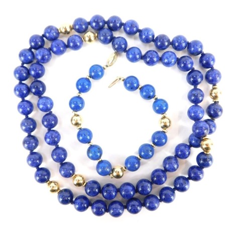 A Lapis Lazuli necklace and bracelet set, the necklace with gold coloured ball breaks, 70cm long, and matching bracelet on string strand with a yellow metal clasp stamped 9k, 16cm long, 116.7g all in. (2)