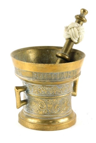 A cast brass pestle and mortar, the mortar decorated with a band of typography for Richard Startyn 1623, decorated with bust of a man amongst bands of flowers, etc, 12cm high, the pestle 20cm long.