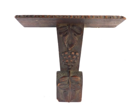 A 19thC oak wall bracket, rectangular shelf with a carved border, raised on a carved column decorated with vine leaves and grapes, 30cm high.