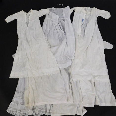 Seven late 19thC/early 20thC cotton christening gowns, some with worked and lace decoration, each on a Sand of London coat hanger.