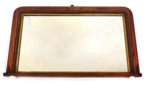 A late 19th/early 20thC walnut and inlaid overmantel mirror, of rectangular form with rounded corners, ceramic castors, 54cm x 89cm.