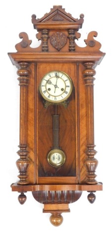 A late 19thC/early 20thC mahogany Vienna wall clock, the cream enamel dial bearing Roman numerals, eight day movement, with pendulum, 85cm high.