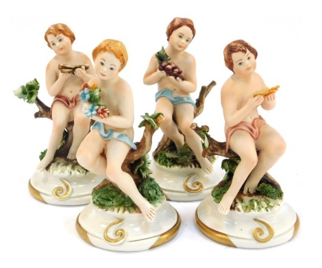 A set of four Capo di Monte porcelain figures, modelled as children seated on branches, on circular gilt heightened base, printed mark, 14cm high.