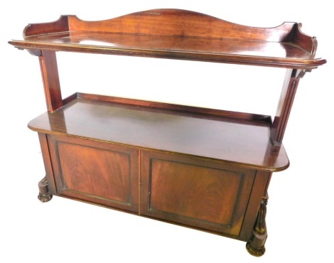 A Victorian mahogany two tier buffet, with a raised back, the first tier with moulded edge, on plain end supports, the base with two panelled doors, flanked by scroll carved brackets, on lobed feet, 107cm high, 130cm wide, 54cm deep.