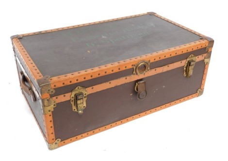 An early 20thC brown and tan leather bound trunk, with brass fittings, named to the lid for M. Dobney Gosberton Risegate, Nr Spalding, 34cm high, 91cm wide, 53cm deep.