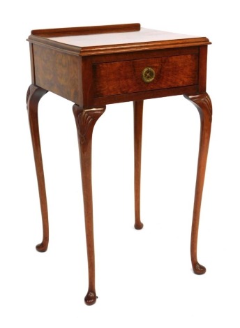 A 20thC walnut bedside table, the rectangular top with raised back, on single drawer, with out splayed shell capped legs, 76cm high, 42cm wide, 43cm deep.