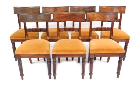 A set of seven William IV mahogany dining chairs, each with a bar back, a drop in seat, on reeded turned tapering legs.