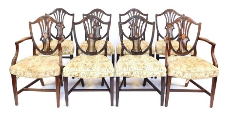 A set of eight late 19th/early 20thC mahogany dining chairs, the shield shaped back carved with wheat ears, inlaid with overall paterae, and with a pierced splat, the padded seat upholstered in tapestry style fabric, on square tapering legs, including two