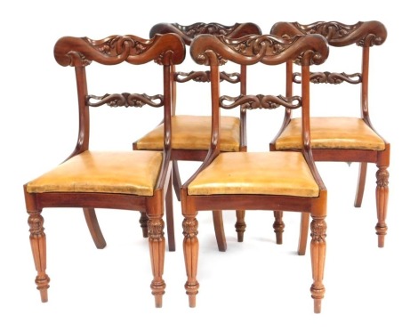 A set of four William IV mahogany dining chairs, each with scroll carved cresting rails, with tan leatherette drop in seats.