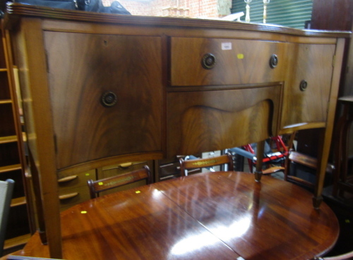 A mahogany serpentine fronted sideboard in George III style, the top with a moulded edge, the base with two drawers, flanked by two cupboards, on splayed legs, 90cm high, 140cm wide, 60cm deep.