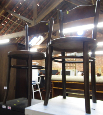 A pair of 1920's oak bentwood chairs, each with a rail decorated with flowers and diamond motifs, solid seat, raised on turned tapering legs.