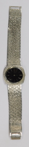 A Piaget wristwatch, with an oval blackened face, with baton markers, with a thirty jewel Swiss movement, serial number 65509512P6ADJ, in white gold stamped 18ct 750 to inner case, case bearing serial number 12441A3 77882, on unmarked strap.