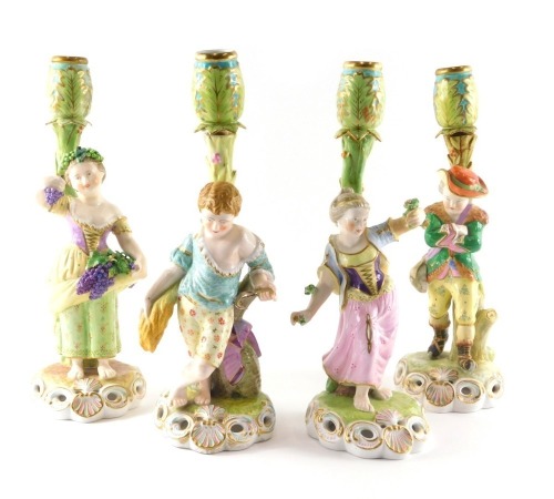 A set of four Stephenson and Hancock Derby figural candlesticks, each emblematic of seasons, depicting figures with grapes, harvesting flowers, and a huntsman, each on pierced rococo scroll at bases, hand scripted Derby mark to underside in puce, 31cm hig