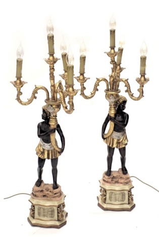 A pair of painted resin blackamoor figural table lamps, each carrying a cornucopia, with four scroll arms, on a stylised rock and rococo scroll pedestal, 108cm high including bulbs. WARNING! This lot contains untested or unsafe electrical items. It is su