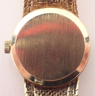 A 9ct gold Omega lady's wristwatch, the gold coloured circular dial, 1.5cm wide, on a bark effect bracelet, 24.8g all in. - 3