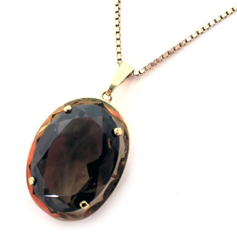 A West German smoky quartz pendant, with oval central stone in claw setting, 4cm high, in gold plated border, on a 9ct gold box link neck chain, 60cm long, 15.5g all in.