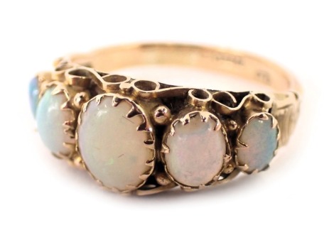 A 9ct gold opal dress ring, the ring head set with five oval opals in rub over and claw setting, with etched shoulders, ring size O½, 2g all in.