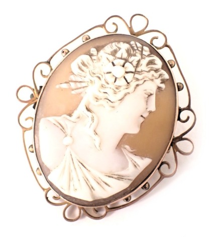 A 19thC shell cameo brooch, depicting maiden looking dexter, with curled hair and robe, in a rose gold coloured pierced border, stamped 9ct, 4.5cm x 3.5cm, with safety chain, 8.4g all in.