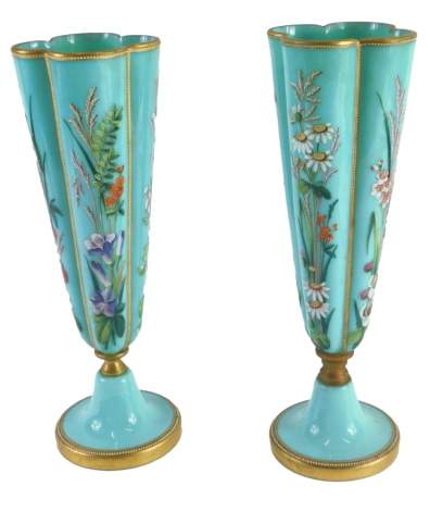 A pair of Victorian turquoise glass vases, each decorated with painted design of floral sprays, with gilt borders, 33cm high. (AF)