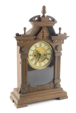 A late 19th/early 20thC American mantel clock, in a stained oak case with Roman numeric dial, on block feet, 50cm high.