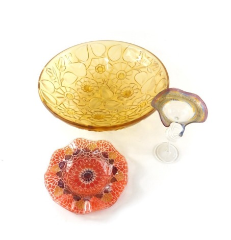 A Sydenham art glass plate, decorated in orange, gold and brown, signed to underside, 16cm diameter, a small art glass centrepiece or stand with gold and purple border and air twist stem, and a French amber coloured Art Glass bowl, unmarked, 29.5cm diamet