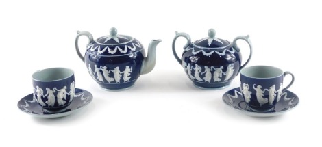 A Copeland ceramic part tea set, decorated in Wedgwood style with raised neoclassical figures in white on a deep blue ground, printed mark in brown to underside, and impressed marks. (6)