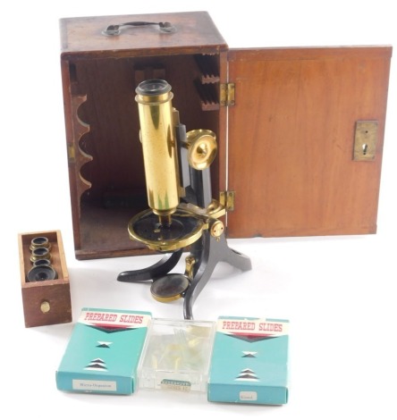 An early 20thC brass and ebonised student's microscope, 25cm high approx, in a mahogany case with some slides.