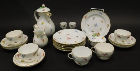 A late Meissen part tea service, etc., to include water or coffee pot and cover, side plates, cups, saucers, two egg cups, milk jug, and a box and cover, each decorated with flower sprays, blue cross swords mark to underside.