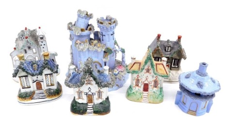 A quantity of Staffordshire pottery cottages, and a two turreted castle, various periods and makers (AF), the castle 18cm high.