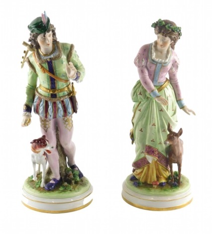 A pair of German porcelain figures, modelled in the form of a lady and gentleman in 18thC dress, with dog and fawn respectively, 34cm high.