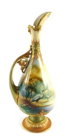 A Royal Worcester porcelain ewer, decorated with a scene of storks beside a lake, signed A. Schuck, within blush ivory and gilt borders, printed marks in green to underside, 36cm high. (AF)