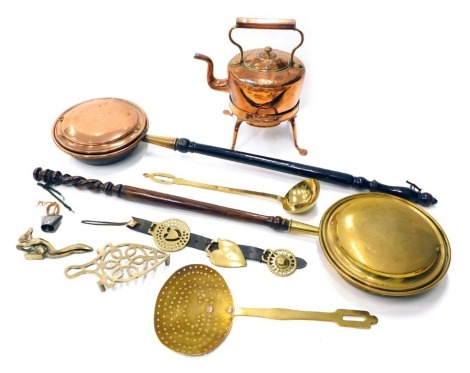 A Victorian brass warming pan, with turned wooden handle, engraved with a peacock, and a copper and brass warming pan, with ebonised handle, a kettle on stand, skimmer, horse brasses, etc. (a quantity)