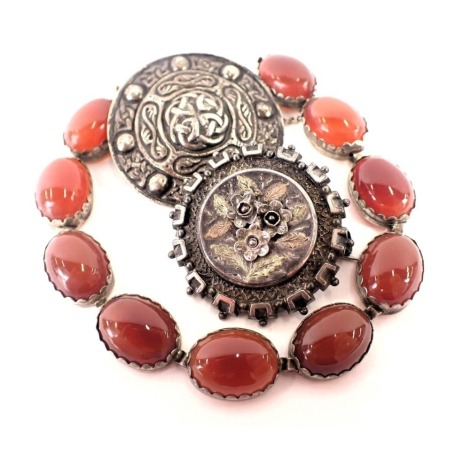 Three pieces of Eastern inspired jewellery, comprising an orange agate set and white metal bracelet, 18cm long, a white metal Celtic medallion brooch, 3.5cm wide, and a Victorian circular rose brooch, with gilt decoration, 3.5cm wide, 50.5g all in. (3)