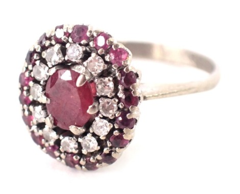 A ruby and diamond dress ring, with raised pave set stones, on a white metal band, unmarked, ring size K½, 4.6g all in, boxed.