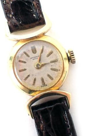 An International Watch Company ladies wristwatch, with small circular dial, in a silvered numeric border, 1.5cm wide, yellow metal unmarked, on a brown leather strap, 11g all in, boxed.